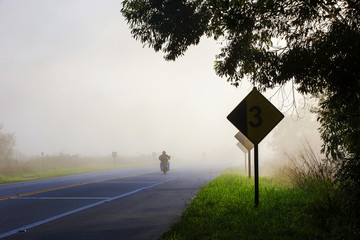 Highway in the morning fog, with motorcycle