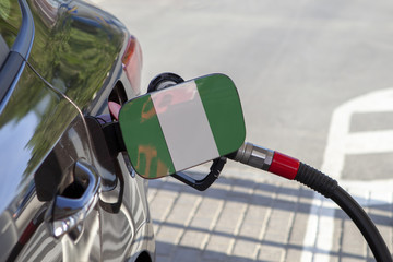 Fueling car with petrol pump at a gas station.