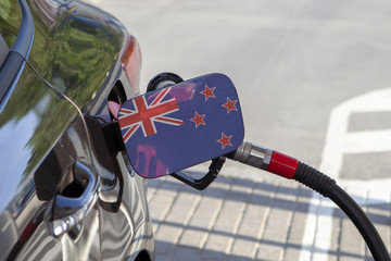 Fueling car with petrol pump at a gas station.