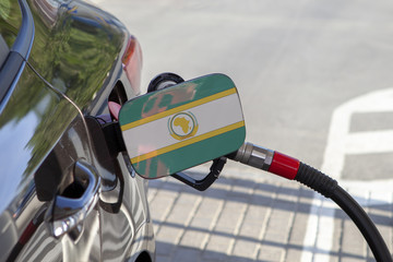 Fueling car with petrol pump at a gas station.