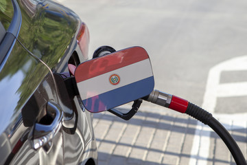 Fueling car with petrol pump at a gas station.