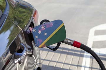 Fueling car with petrol pump at a gas station.