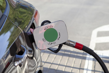 Fueling car with petrol pump at a gas station.