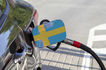 Fueling car with petrol pump at a gas station.