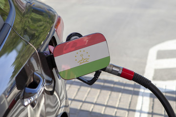 Fueling car with petrol pump at a gas station.