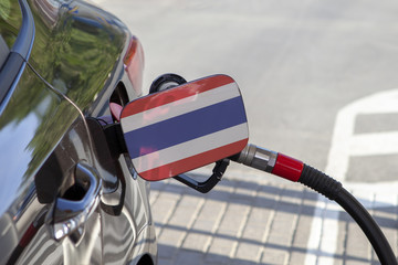 Fueling car with petrol pump at a gas station.