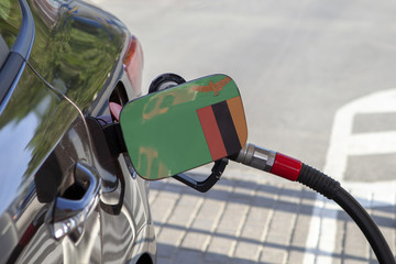 Fueling car with petrol pump at a gas station.