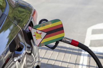 Fueling car with petrol pump at a gas station.