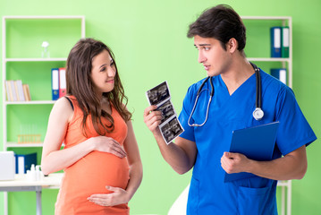 Pregnant woman visiting male gynecologyst at the clinic