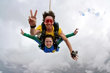 Gardinen Skydiving tandem happiness on a cloudy day © Mauricio G
