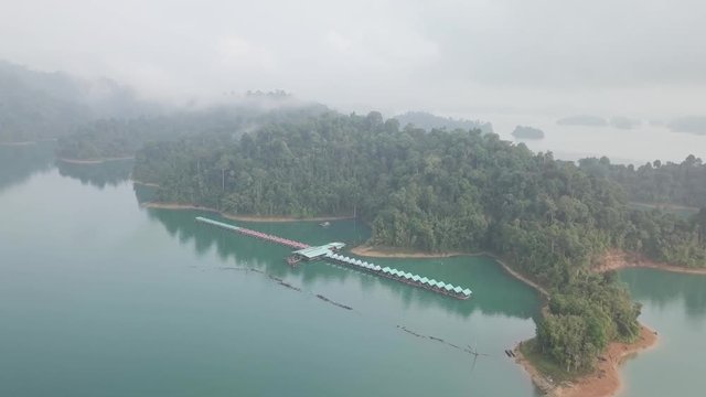 4K Aerial Drone Footage moving in towards a boat house on the aqua blue lake in a national park wilderness