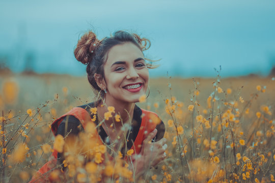 Mujer sonriendo entre las flores en el campo