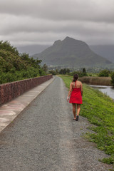 Woman in a red dress walking along a path in Hawaii