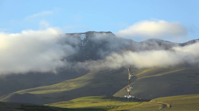 Timelaps of Kuray mountain range with repeater fnd running clouds on blue sky in evening time. Altai Mountains