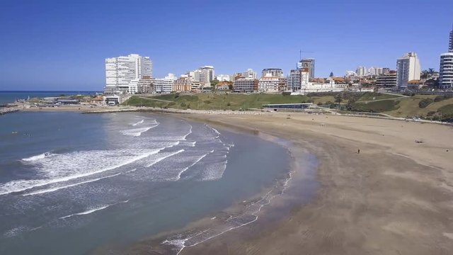 Playa Varese on the coast of Mar del Plata Argentina – 4k drone video of the Argentinian coast and downtown area of Mar del Plata Casino Central in spring time.  Buenos Aires Capital Federal district 