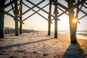Chair under the pier at sunrise