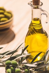 Bottle of Olive Oil with Green Olives on the Branch