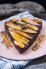 Vegan sweet cake. Raw chocolate pie. Vegetarian tart piece with bananas, maple syrup, dates, coconut and dark cocoa powder. Delicious and healthy breakfast or dessert.