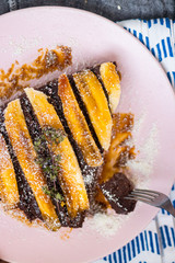 Vegan sweet cake. Raw chocolate pie. Vegetarian tart piece with bananas, maple syrup, dates, coconut and dark cocoa powder. Delicious and healthy breakfast or dessert.