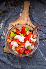 Salad with tomatoes, cauliflower and cucumber. Close up view. On wooden board. Vegetarian and vegan healthy food. Fresh raw vegetables.