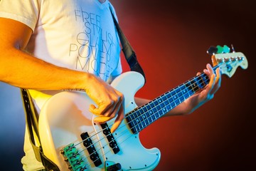 Closeup of a Musician Playing an Electric Bass - obrazy, fototapety, plakaty