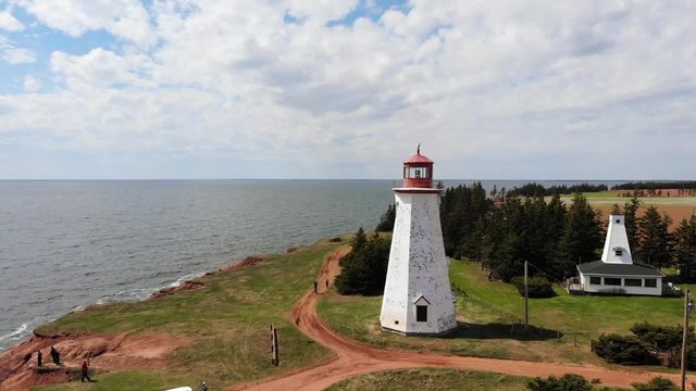 Lighthouse by the seashore, cars and tourists