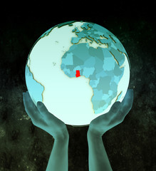 Ghana on blue globe in hands