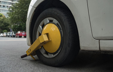 Obraz premium Car wheel blocked by wheel lock because illegal parking violation