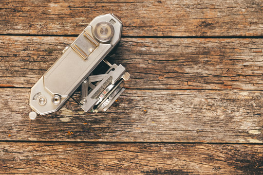 Old 35mm camera on weathered wooden background