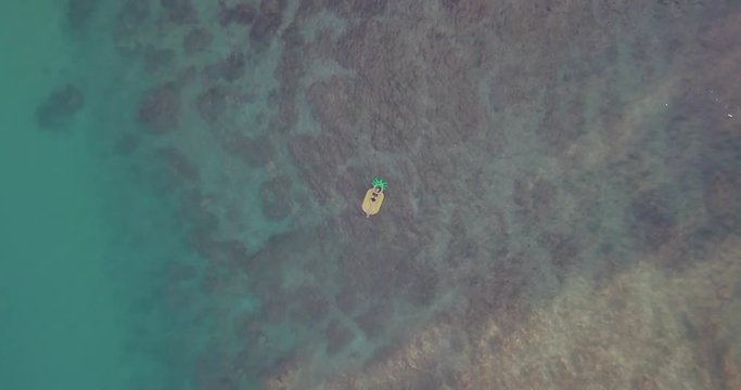 4k Drone Footage Of Model On Pineapple Floatie Flying Upwards To Reveal Turquoise Ocean And Reef