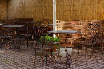 Chairs and tables in cozy outdoor cafe at summer