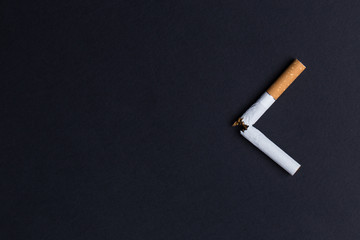 Broken cigarette on black background close-up