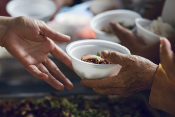 hands of the poor receive food from the donor's share. poverty concept