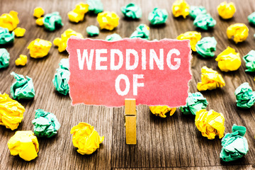 Word writing text Wedding Of. Business concept for announcing that man and woman now as married couple forever Clothespin holding pink note paper crumpled papers several tries mistakes.