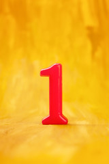 Red number one on a golden background with copyspace