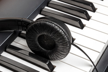 A photo of piano keys with headphones, recording music, with copyspace