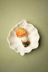 Mushroom fly agaric toadstool in a ceramic bowl on a pale green background, the concept of autumn, psychedelic, poisonous food, danger