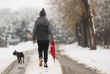 Boy walking down the snowy street