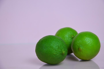 lime juice with lime leaves on pink table. Detox diet. top view. copy space. three limes