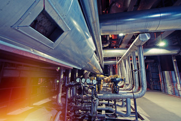 Equipment, cables and piping as found inside of a modern industrial power plant. Industrial zone, Steel pipelines, valves, cables and walkways