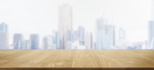 Empty wood table top and blur glass window wall city building background with vintage filter - can used for display or montage your products.