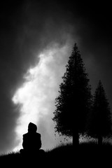 silhouette of someone sitting and watching the approaching storm
