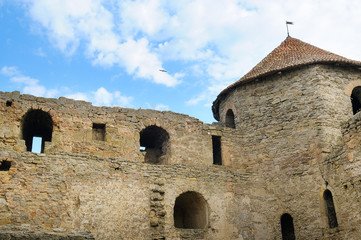Fototapeta na wymiar Fortress tower with tiled roof on blue sky background. Location place Ukraine, Europe.