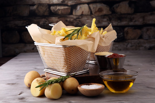 french fries, chips on wooden background with salt