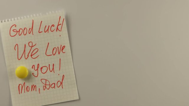 Message on pieces of paper from parents to teenagers on a white surface