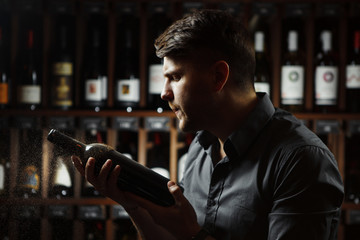 Sommelier holding wine bottle covered with dust