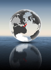 New Zealand on translucent globe above water