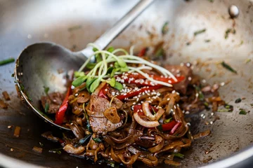 Foto op Canvas Cooking wok beef noodles with microgreen on a pan © boytsov