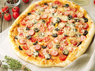 Homemade lagge pizza with parmesan, oregano, olives and mozzarella, sausage and tomato sauce, side view