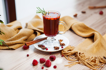 Hot mulled wine in glass with cinnamon sticks and cinnamon